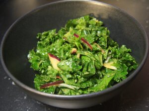 Kale salad with miso dressing, sesame oil, and thinly sliced onions