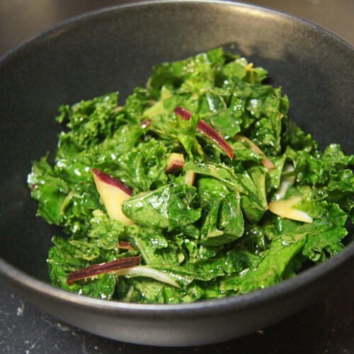 Kale salad with miso dressing, sesame oil, and thinly sliced onions