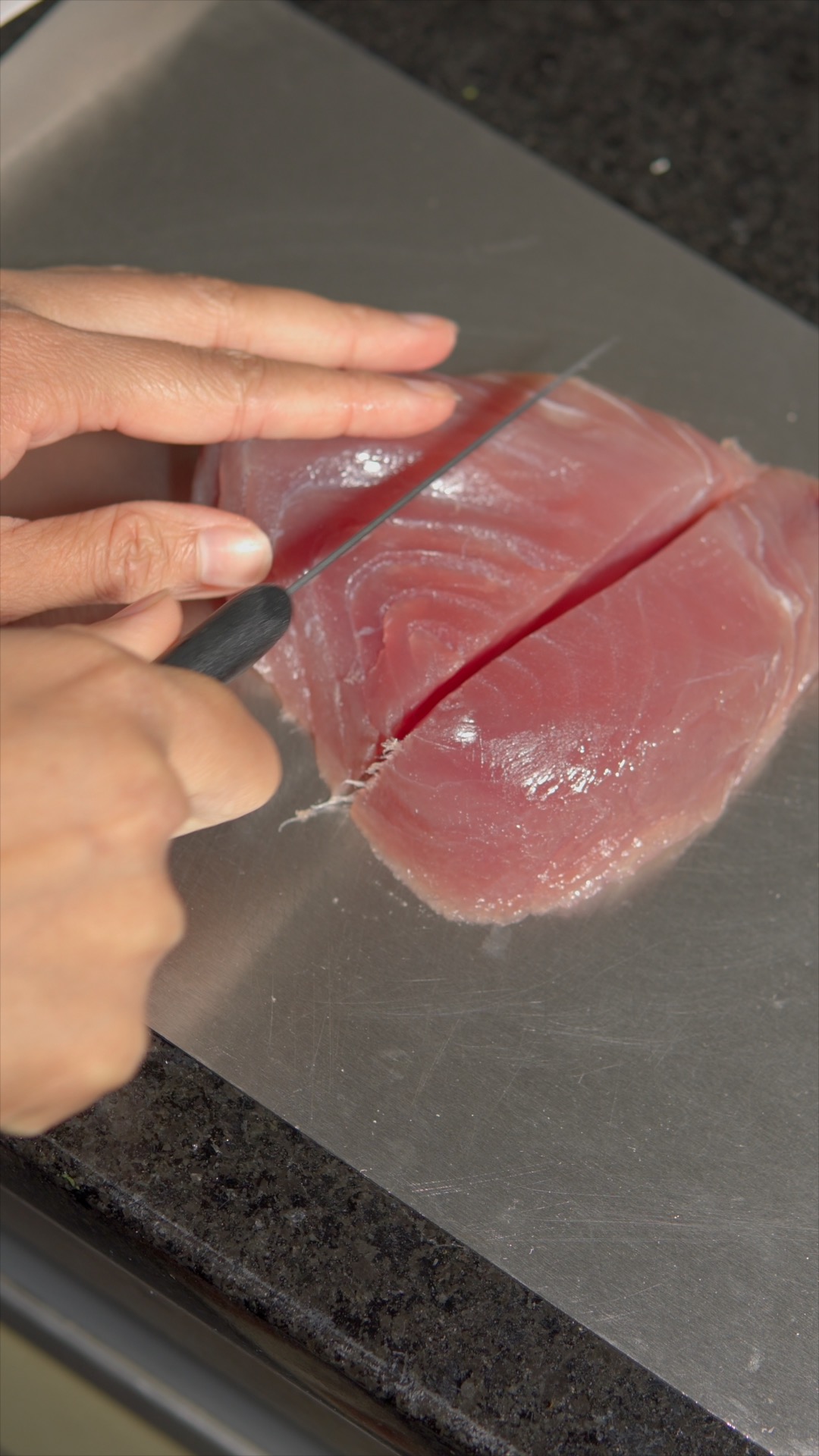 Cutting fresh tuna into cubes for ambul thiyal