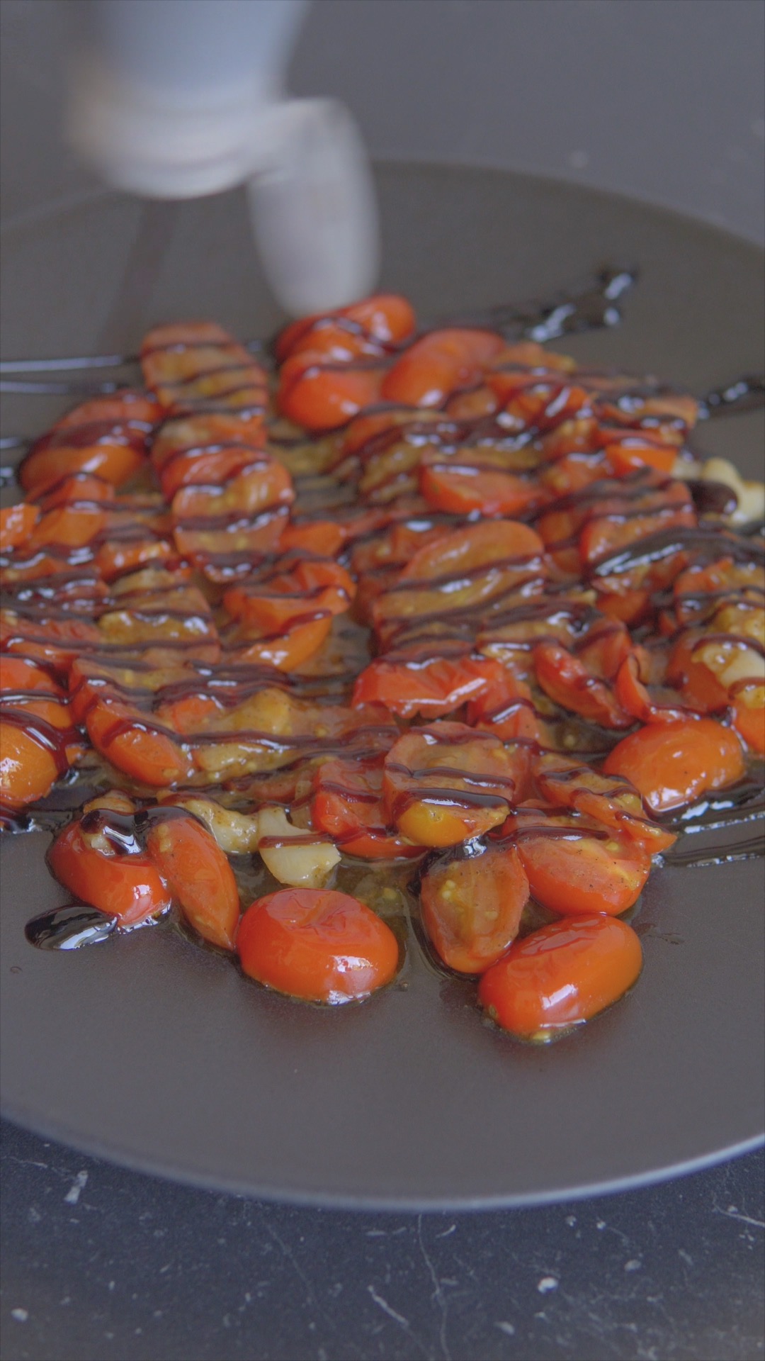 Balsamic glaze drizzled over cooked cherry tomatoes